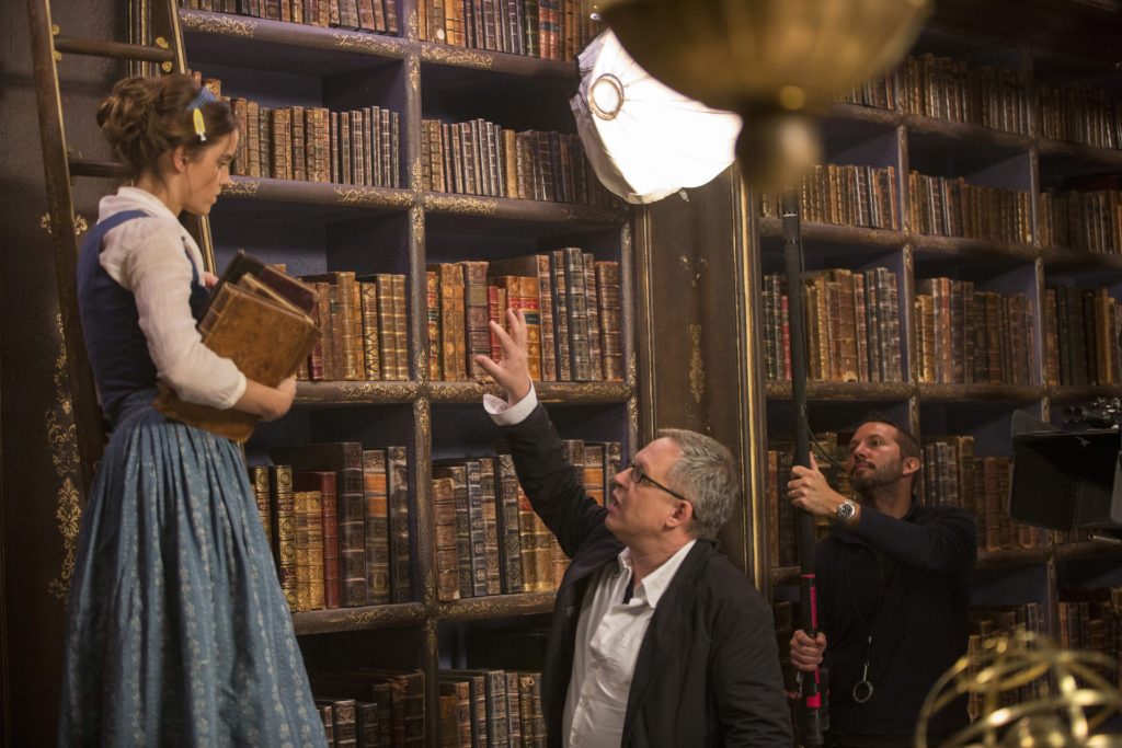 Director/co-screenwriter Bill Condon on set with Belle (Emma Watson) in Disney's BEAUTY AND THE BEAST, a live-action adaptation of the studio's animated classic. The story and characters audiences know and love are brought to life in this stunning cinematic event...a celebration of one of the most beloved stories ever told.